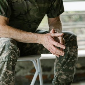 Close-up of a military veteran's hands in a therapy session, emphasizing mental health support.